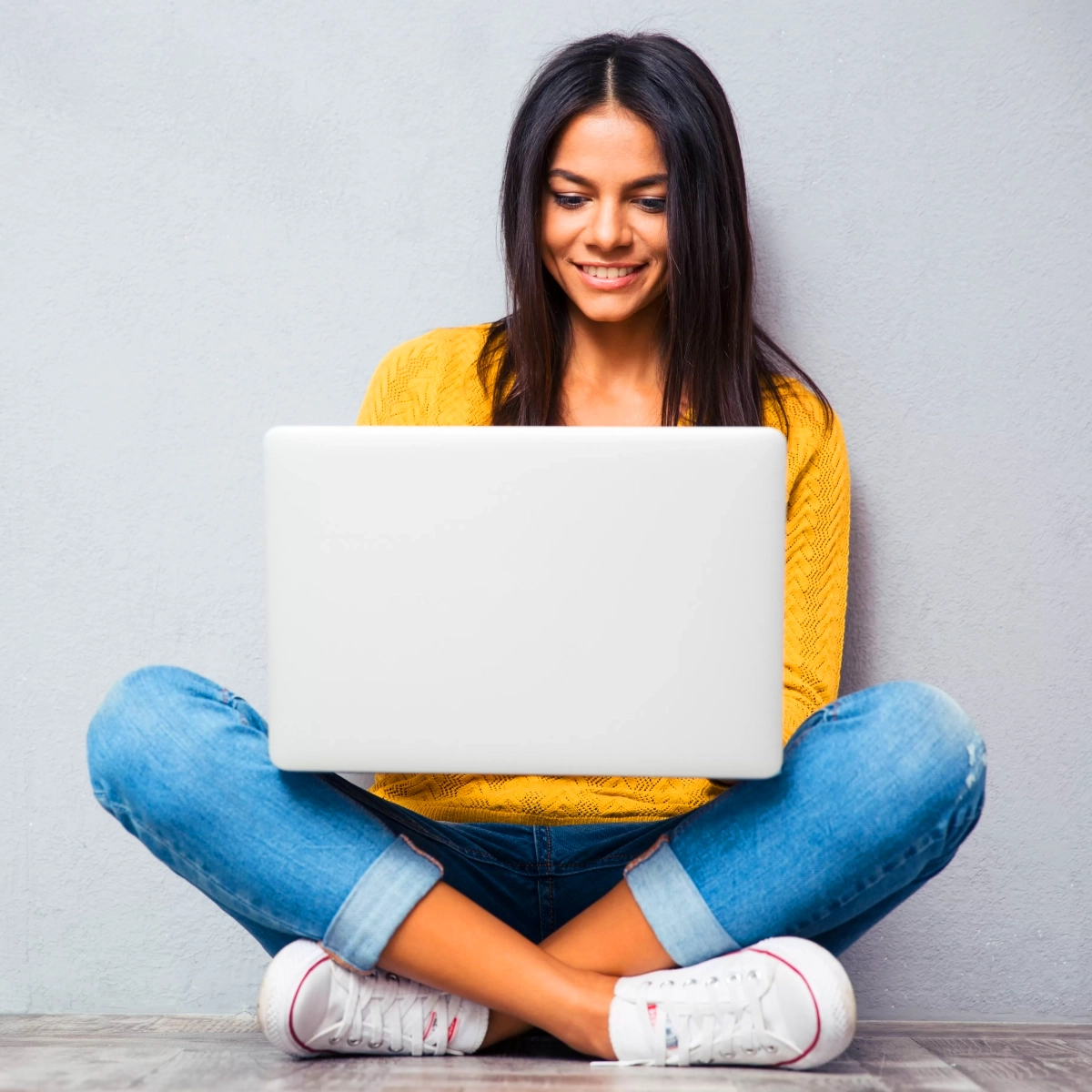 Chica sentada con laptop buscando páginas web